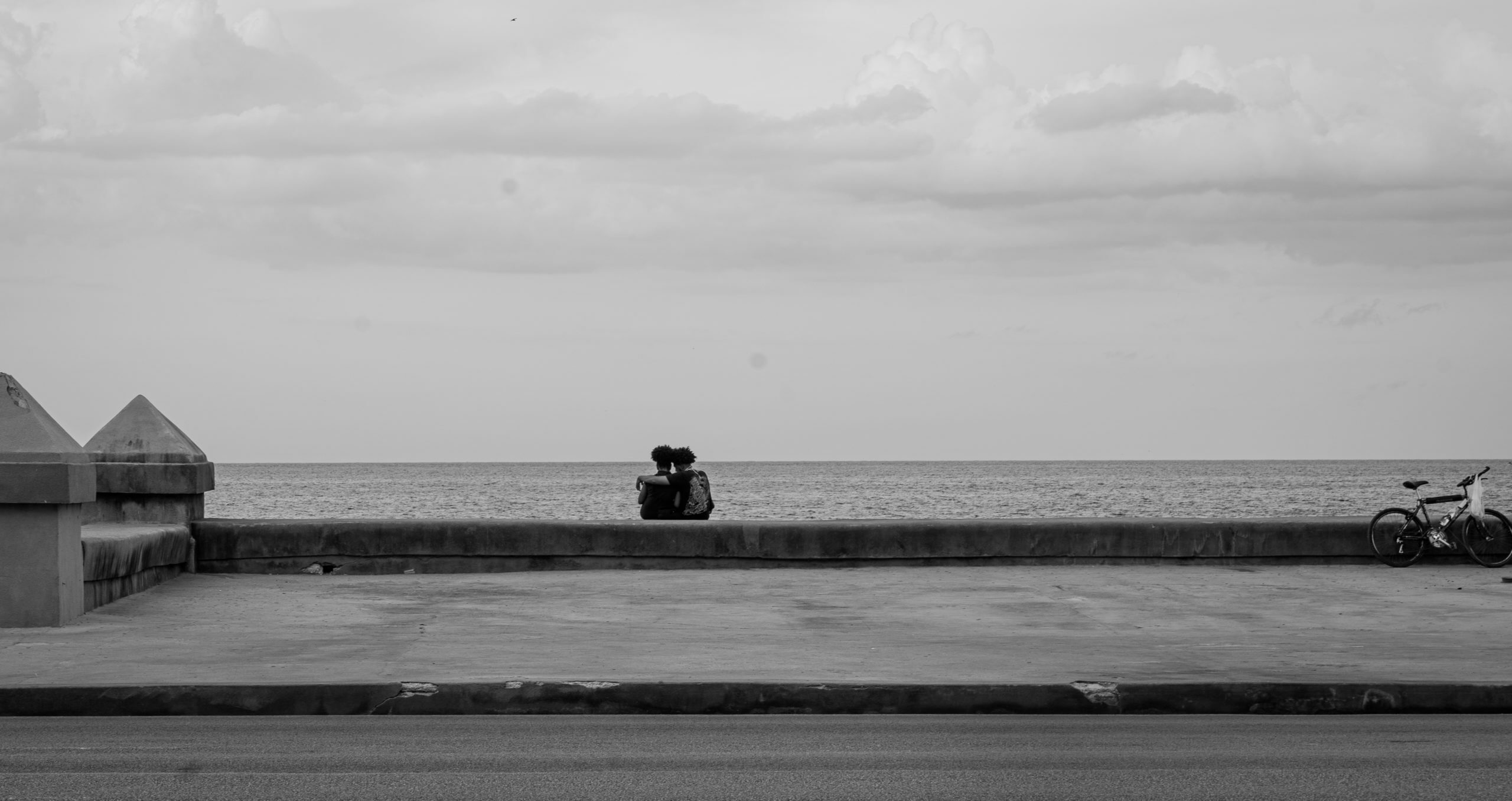 Two lovers enjoy the Malecón, a seaside protective wall that stretches for some miles along the older districts of Havana, Cuba. © 2022 John D. Elliott • www.TheHumanPulse.com