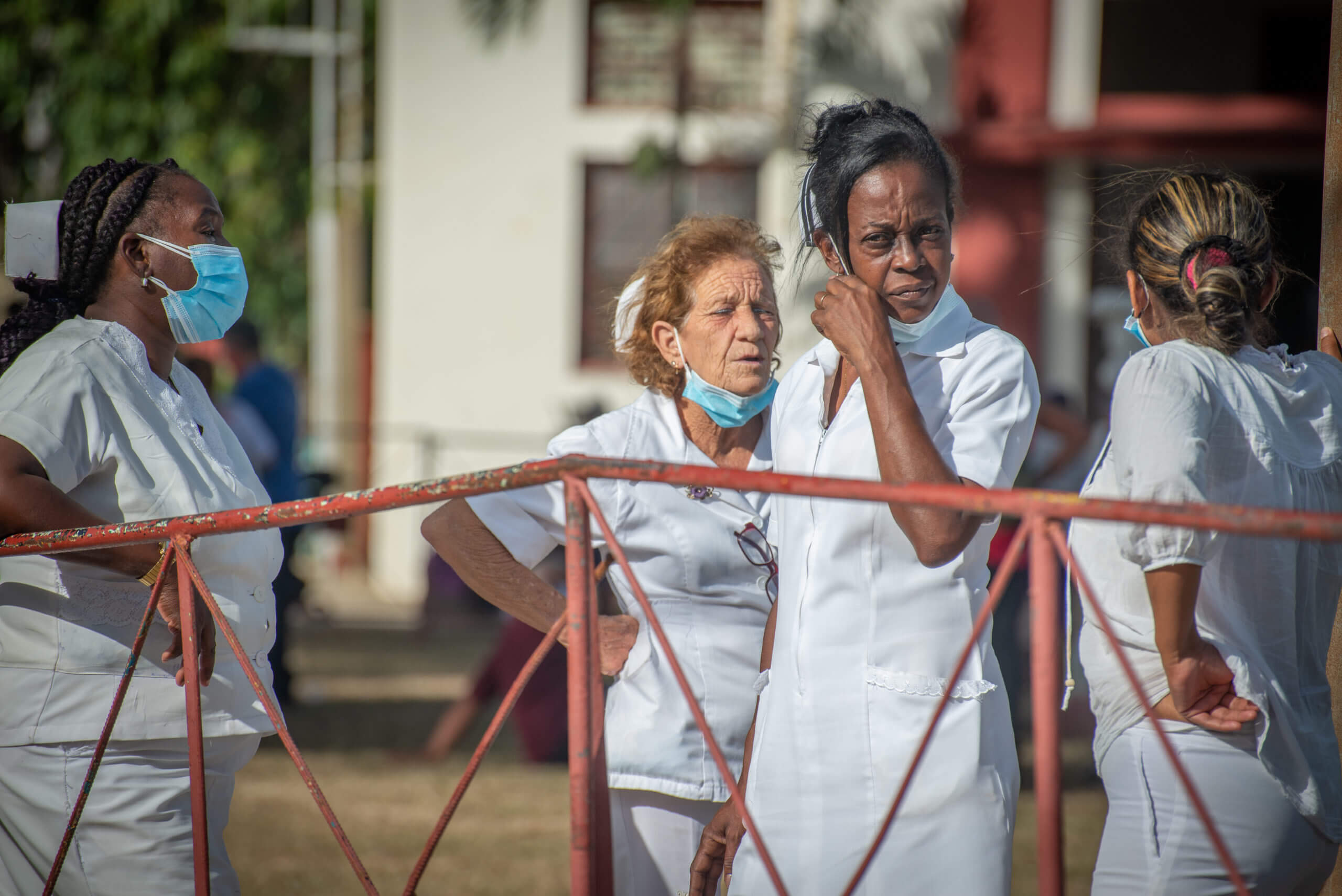 Cuban medics, such as these nurses outside the Church of San Lazaro near Havana, continue to play an integral role in Cuba's successful COVID combat. Cuban children, such as this girl outside the Church of San Lazaro, sometimes doff their "nasobuco," or facemask. © 2022 John D. Elliott • www.TheHumanPulse.com